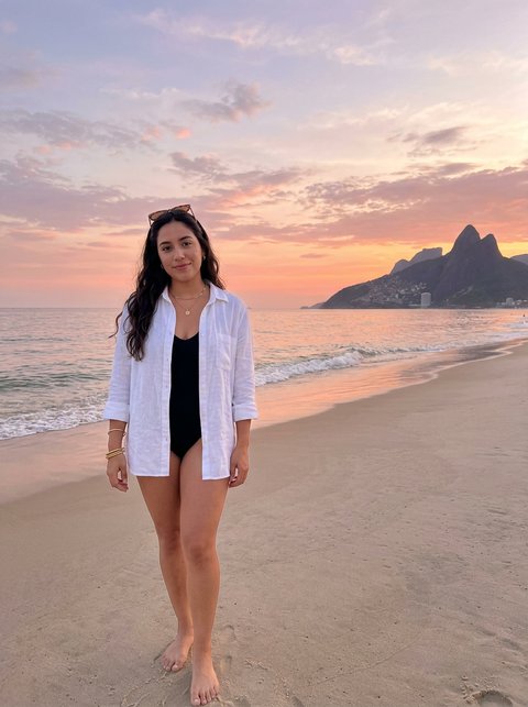 Reference: a woman on a beach at sunset, full body, island behind her